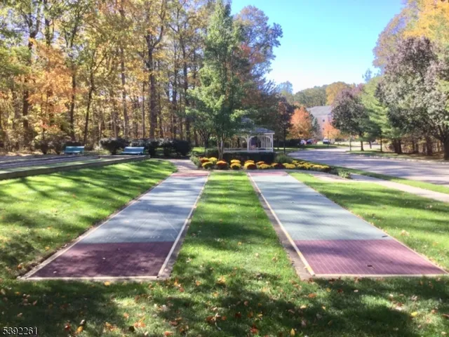 a view of swimming pool with lawn chairs and a big yard
