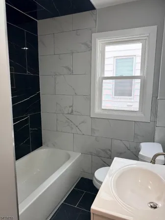 a bathroom with a tub a window and a shower