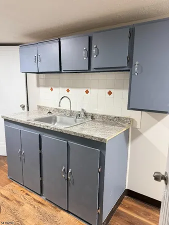 a kitchen with granite countertop a sink and cabinets
