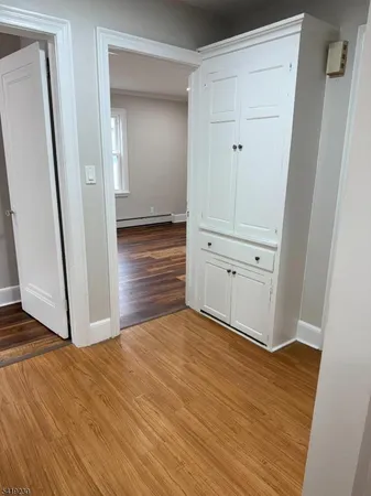 an empty room with wooden floor and entrance