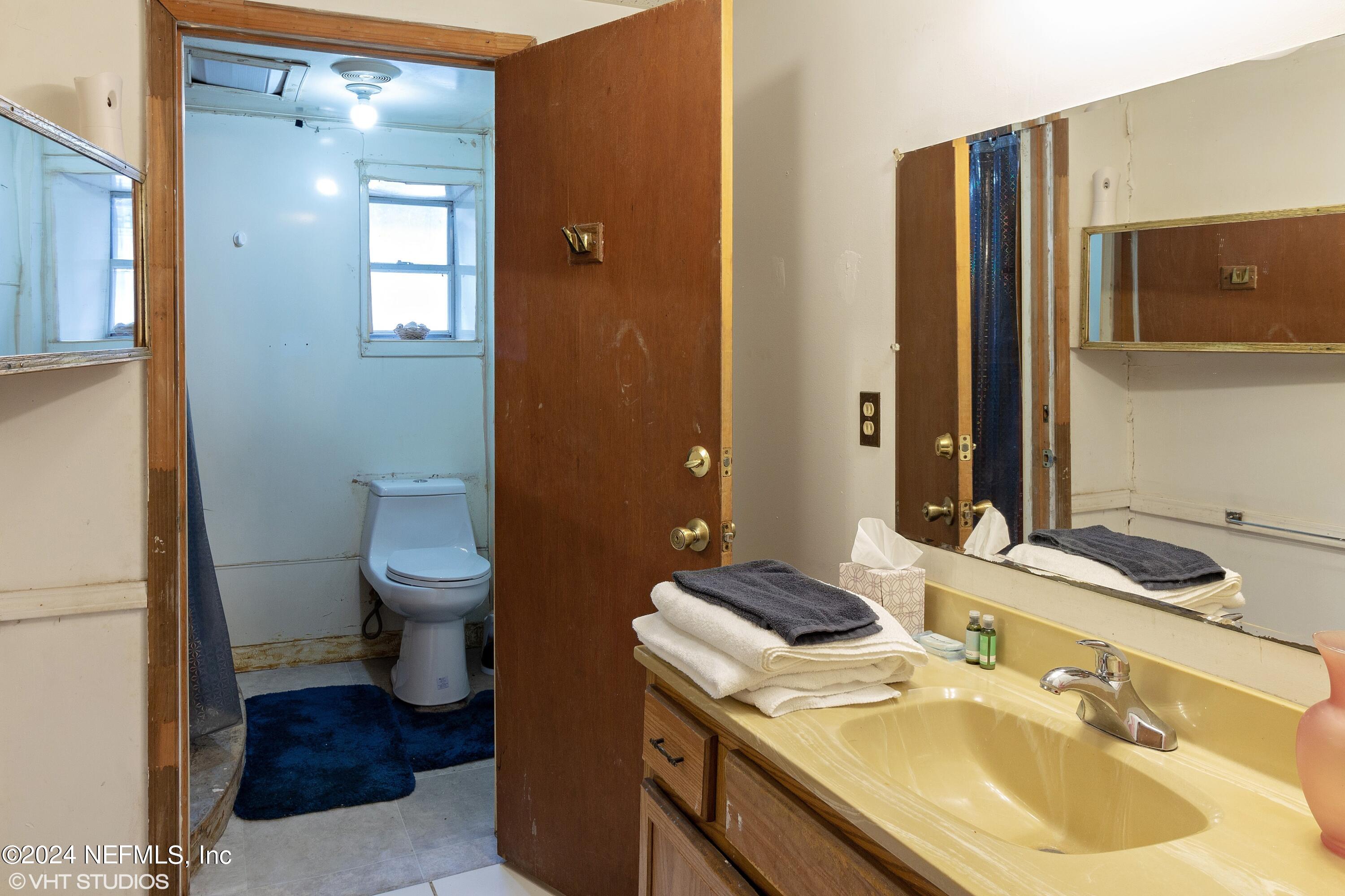 5419 Woodcrest Road Jacksonville, FL 32205 - Photo 11 of 25 a bathroom with a sink toilet and mirror
