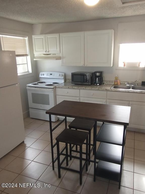 5419 Woodcrest Road Jacksonville, FL 32205 - Photo 22 of 25 a kitchen with granite countertop a stove a sink and a refrigerator