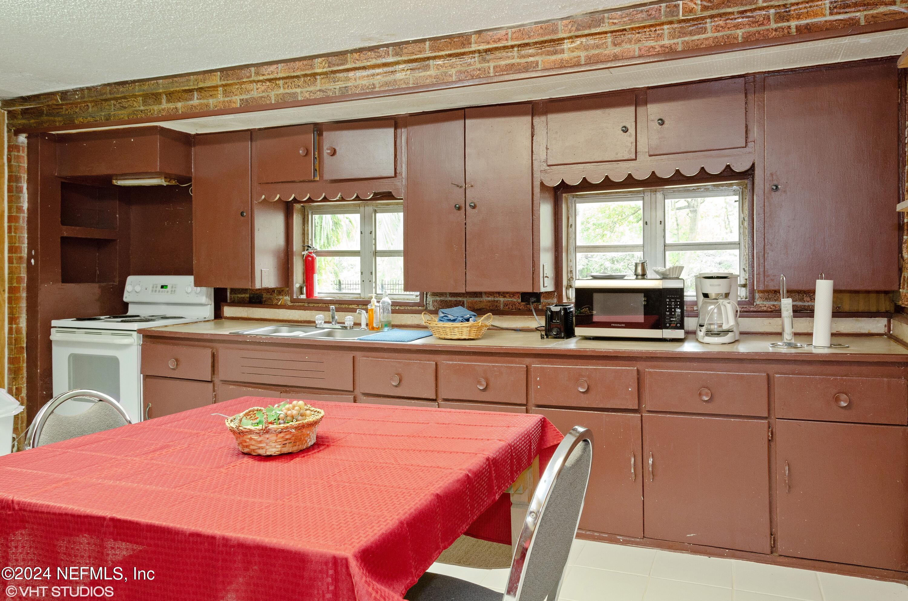 5419 Woodcrest Road Jacksonville, FL 32205 - Photo 8 of 25 a kitchen with a dining table and chairs