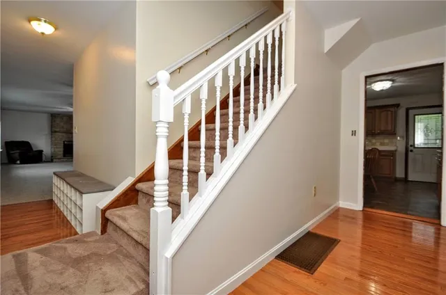 a view of an entryway with wooden floor and a livingroom view
