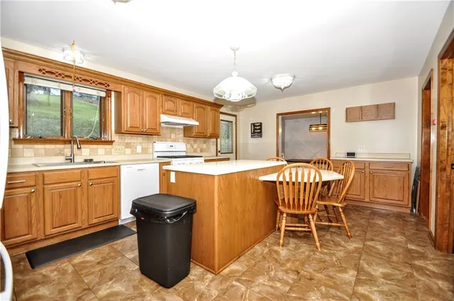 a kitchen with a table chairs sink and cabinets