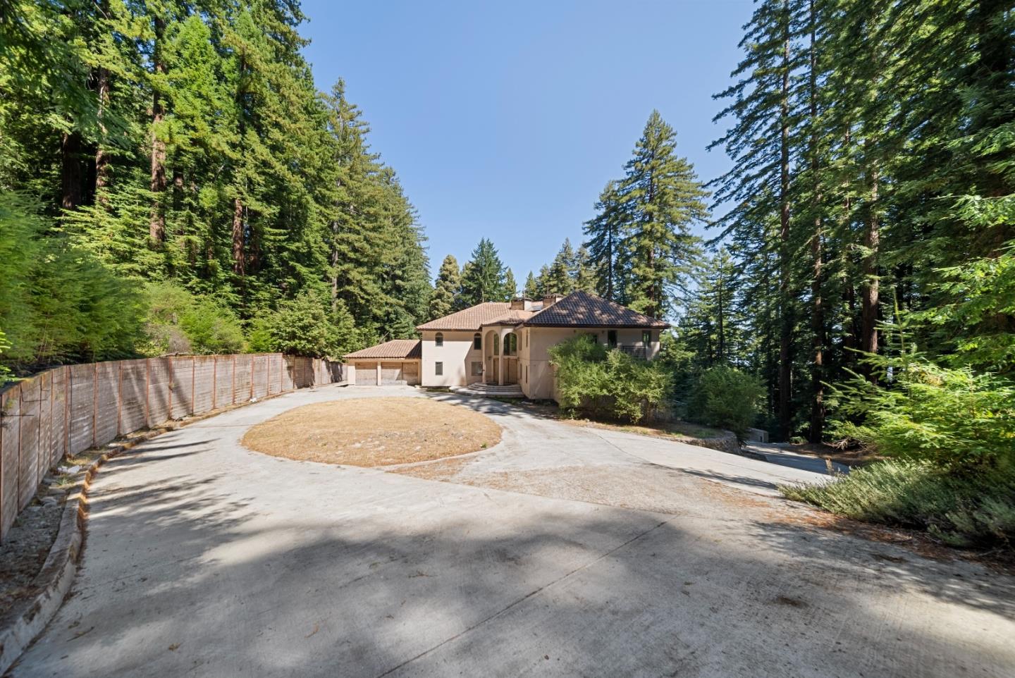 1 Reids Roost Road Woodside, CA 94062 - Photo 15 of 24 a backyard of a house with table and chairs under an umbrella