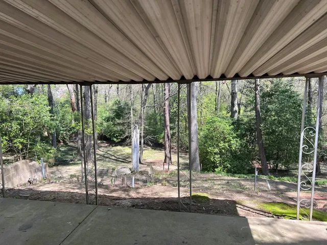 a view of a patio with a table chairs and a floor to ceiling window