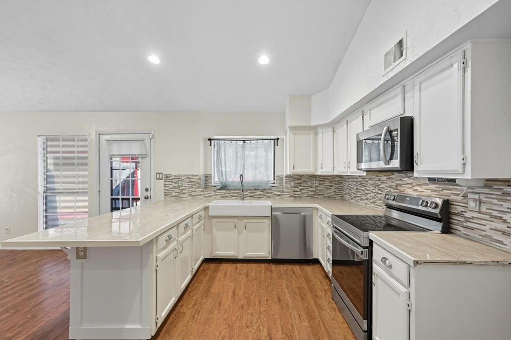 9101 Denver Street Rowlett, TX 75088 - Photo 13 of 40 a kitchen with a sink stove and cabinets