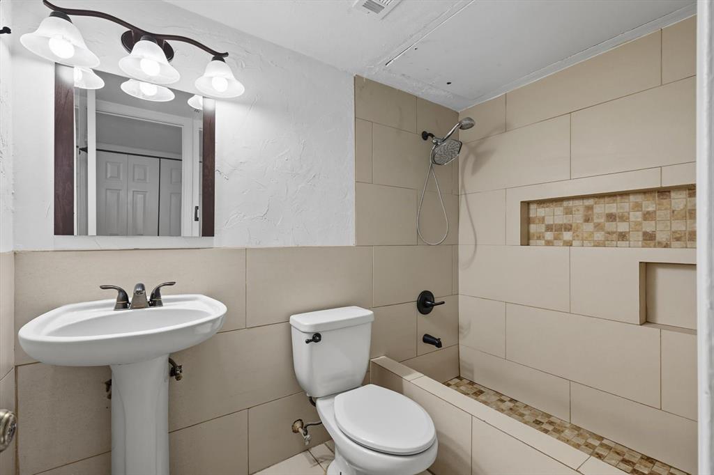 9101 Denver Street Rowlett, TX 75088 - Photo 27 of 40 a bathroom with a toilet sink shower and mirror