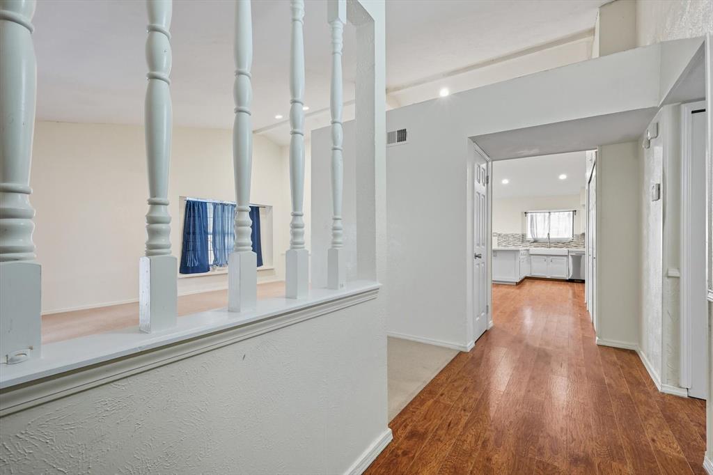 9101 Denver Street Rowlett, TX 75088 - Photo 5 of 40 a view of a hallway with wooden floor and a bathroom