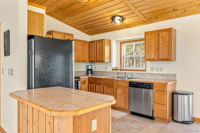 a kitchen with stainless steel appliances granite countertop a sink a stove and refrigerator