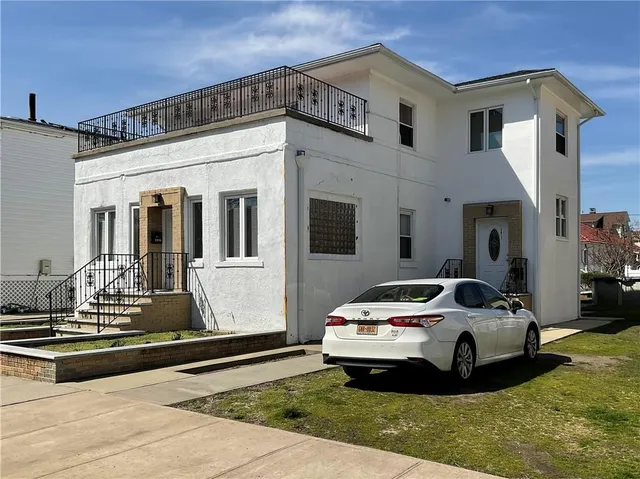 a car parked in front of white house