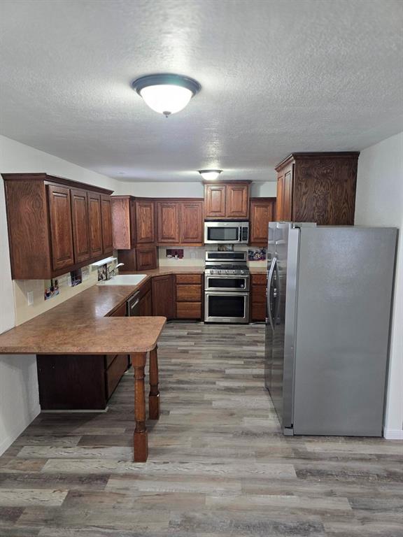 a kitchen with kitchen island a wooden floor and a refrigerator