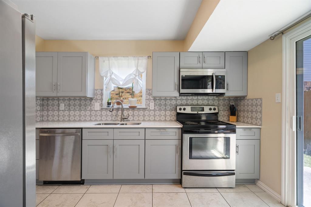 2960 Harbinger Lane Dallas, TX 75287 - Photo 13 of 25 a kitchen with a sink stove and microwave