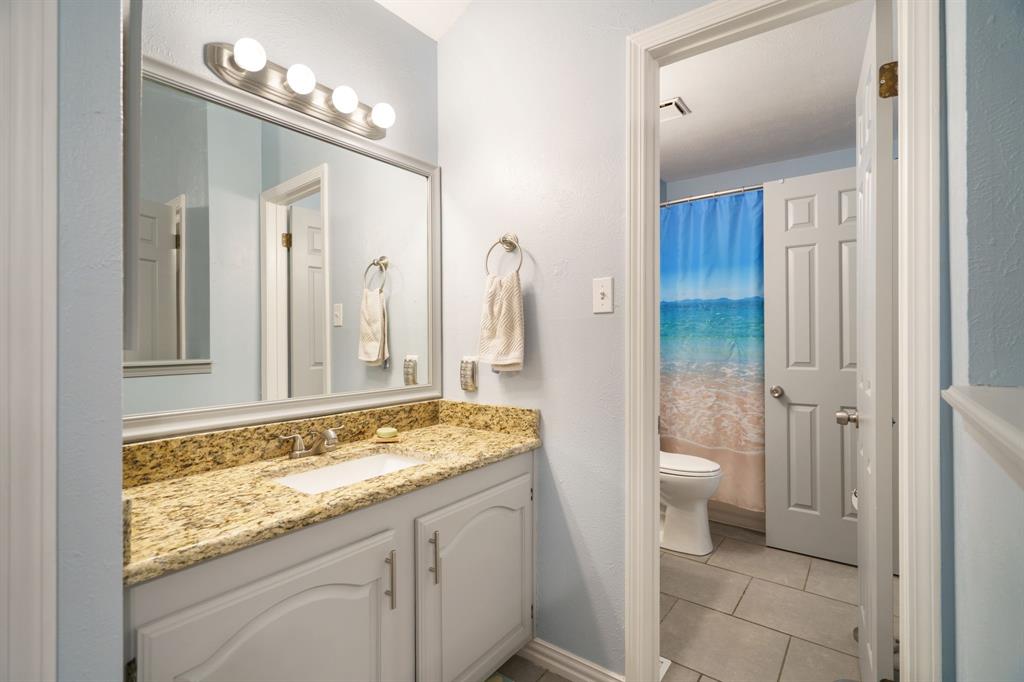 2960 Harbinger Lane Dallas, TX 75287 - Photo 20 of 25 a bathroom with a granite countertop sink and a mirror