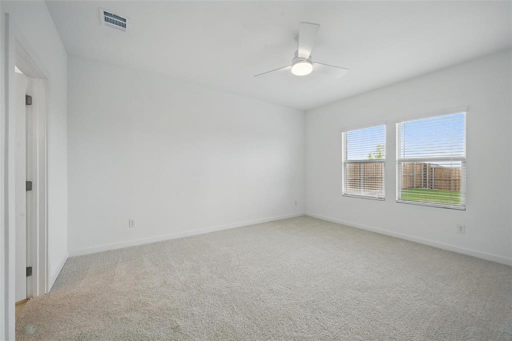 1413 Richardson Street Howe, TX 75459 - Photo 19 of 30 Carpeted room featuring a ceiling fan with integrated lighting, two windows with blinds, and white walls