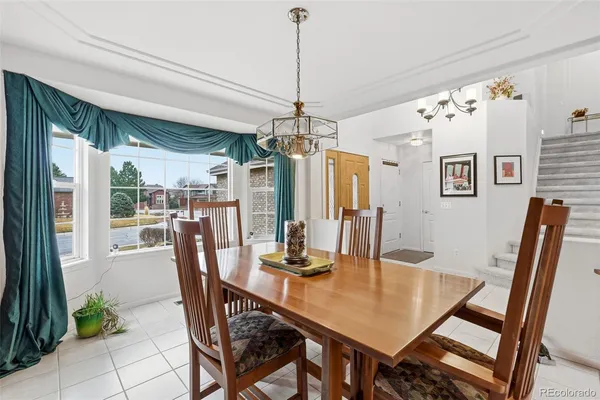 a dining room with furniture a chandelier and wooden floor