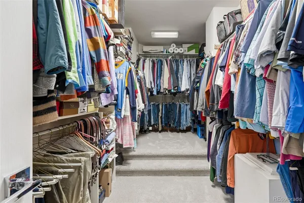 a view of walk in closet with clothes and shoes