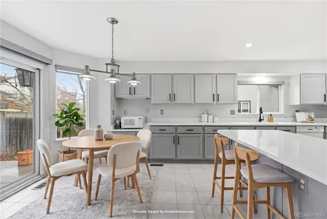a kitchen with a table chairs refrigerator and cabinets