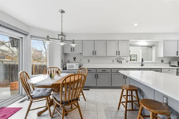 a kitchen with a dining table chairs and white cabinets