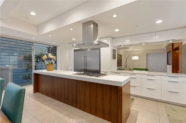 a large kitchen with a large counter top sink and stainless steel appliances