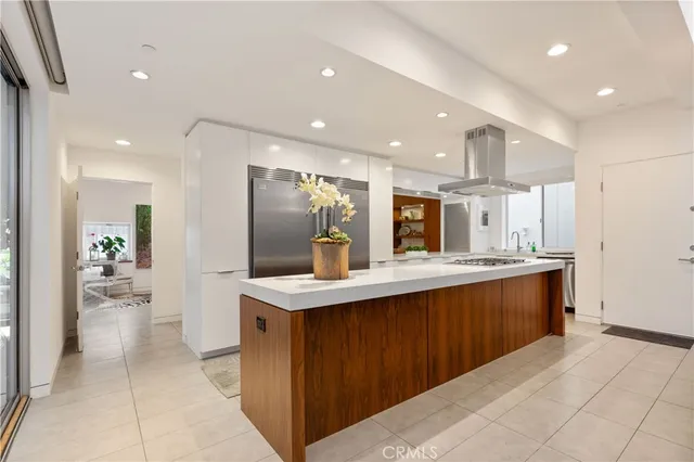 a large kitchen with stainless steel appliances kitchen island granite countertop a large counter top a sink and a refrigerator