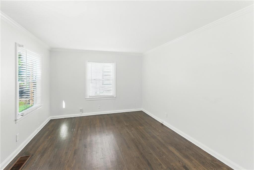 1411 Mercer Avenue Atlanta, GA 30337 - Photo 5 of 21 an empty room with wooden floor and windows