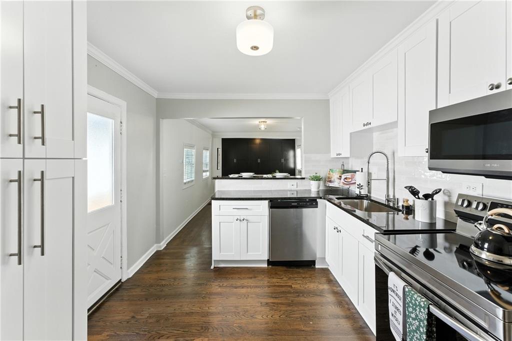 1411 Mercer Avenue Atlanta, GA 30337 - Photo 7 of 21 a kitchen with stainless steel appliances a sink dishwasher a stove and a microwave oven with cabinets