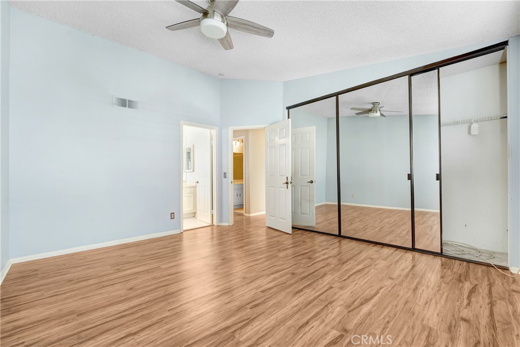 5514 Las Virgenes Road Calabasas, CA 91302 - Photo 12 of 20 a view of an empty room with wooden floor and a ceiling fan