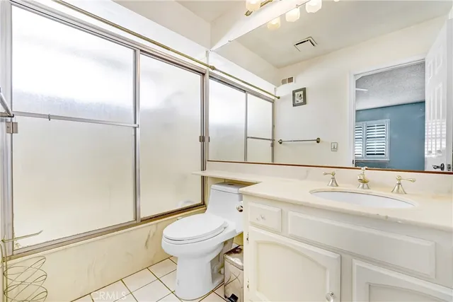 a bathroom with a sink a toilet and a large mirror