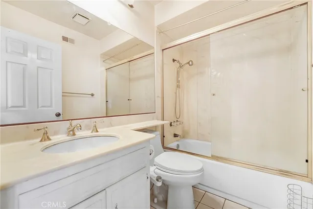 a bathroom with a sink a mirror a toilet and shower