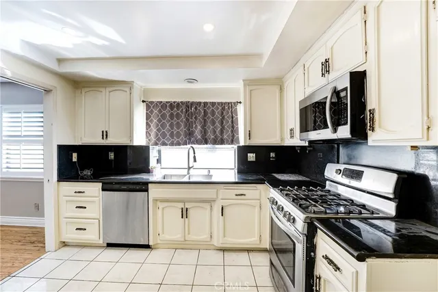 a kitchen with stainless steel appliances a stove a sink and a microwave
