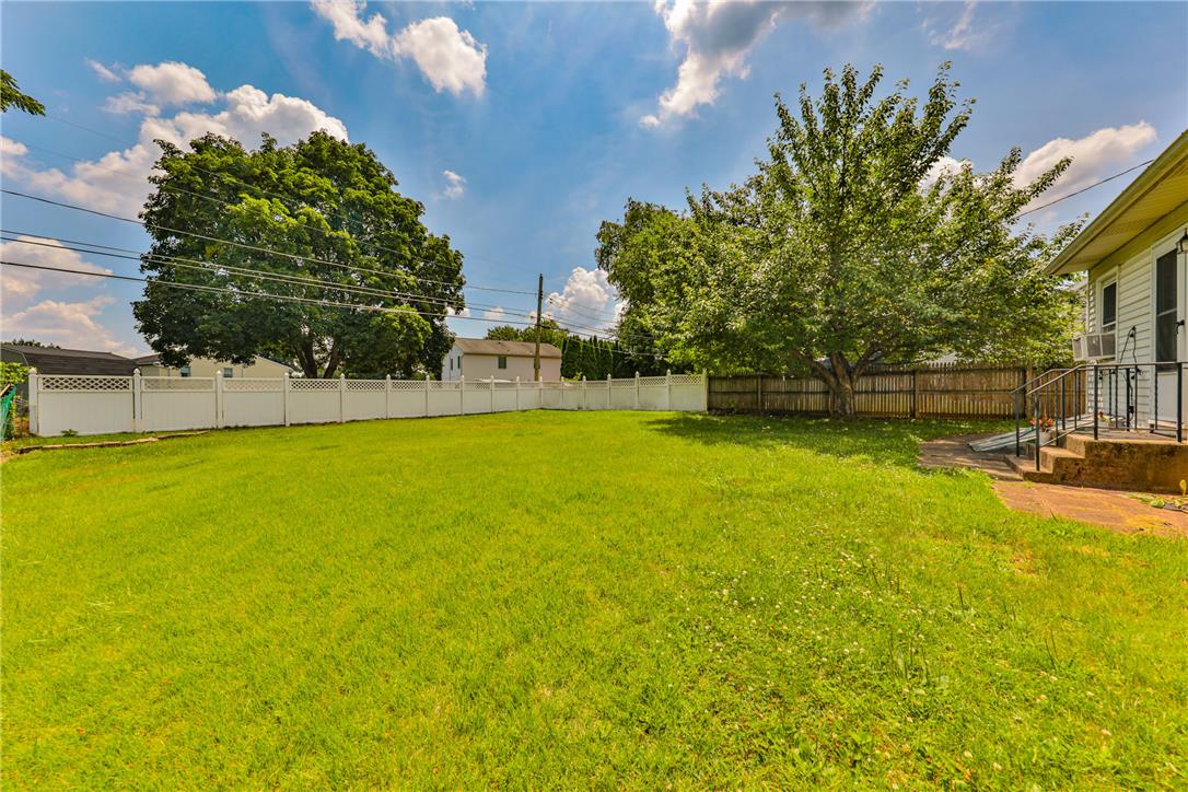 3050 Cornwall Road Bethlehem, PA 18017 - Photo 71 of 80 A verdant lawn offers ample space for outdoor enjoyment, framed by sturdy fencing and mature trees.