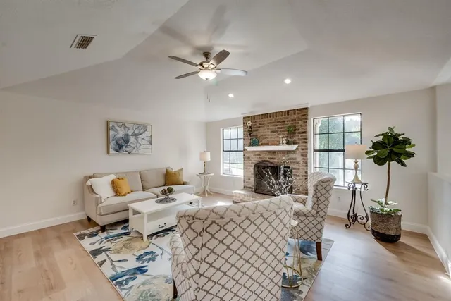 a living room with furniture a fireplace and potted plants