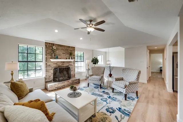 a living room with furniture a fireplace and a large window