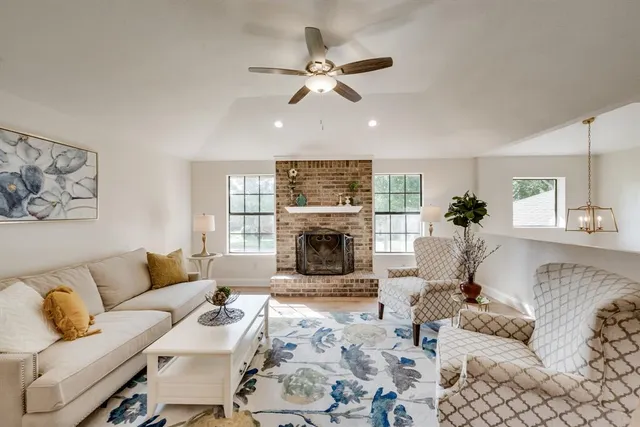 a living room with furniture a fireplace and a chandelier