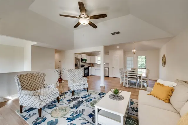 a living room with furniture and a view of kitchen