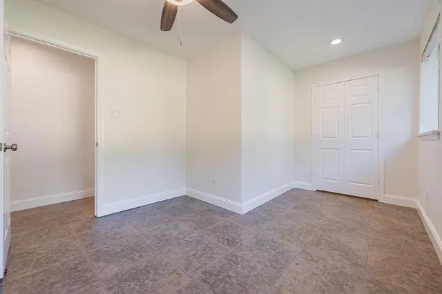 an empty room with closet and windows