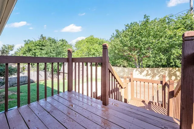 a balcony with wooden floor and fence