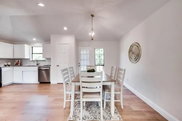 a view of a dining room with furniture and a kitchen view