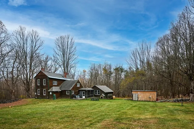 a view of a house with a big yard and a large tree