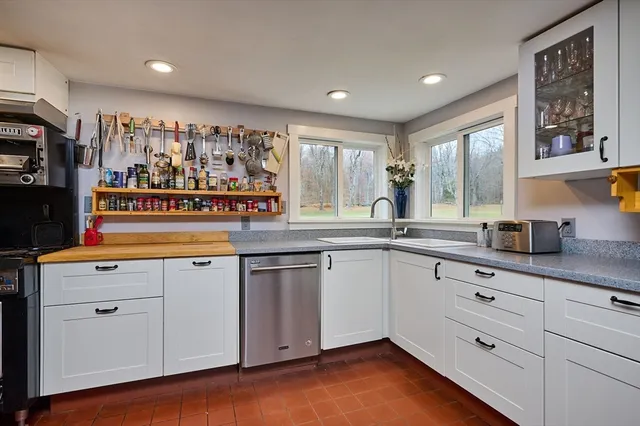 a kitchen with white cabinets and sink
