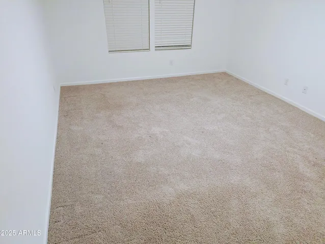 an empty room with wooden floor & windows