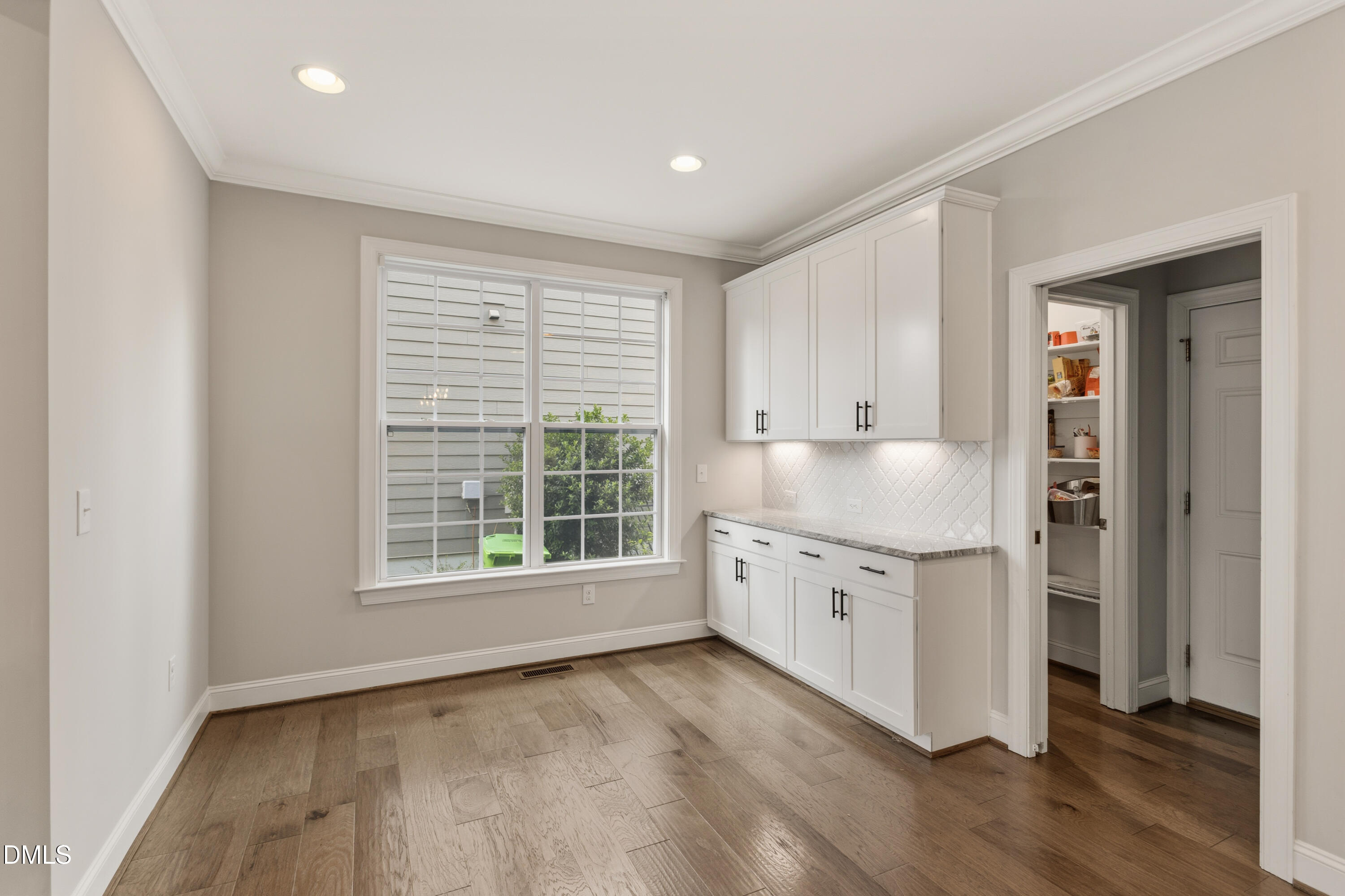 7421 Stonehenge Farm Lane Raleigh, NC 27613 - Photo 18 of 48 a kitchen with granite countertop white cabinets and wooden floor