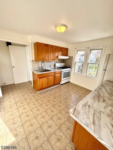 a view of kitchen with wooden cabinets