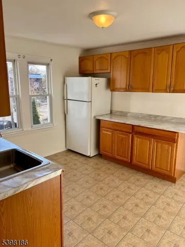 a kitchen with a refrigerator sink and cabinets