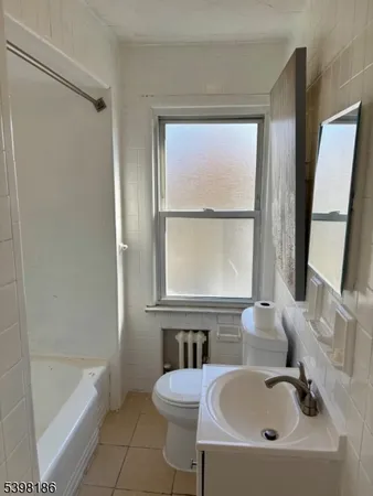 a bathroom with a sink a bathtub and next to a window