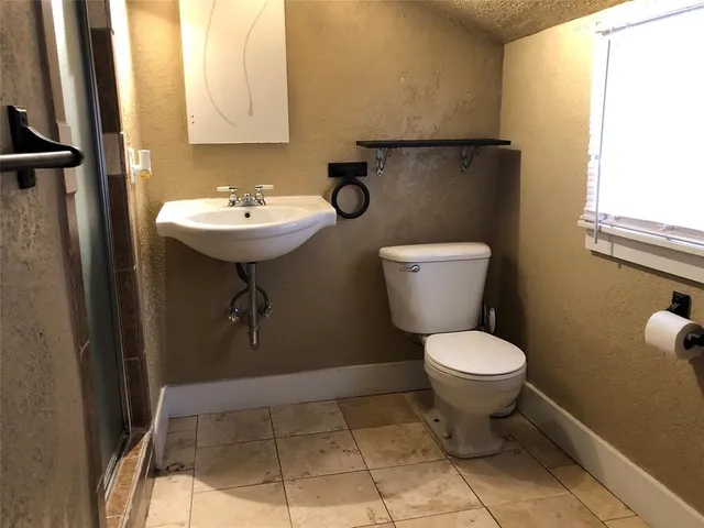 a bathroom with a toilet sink and mirror