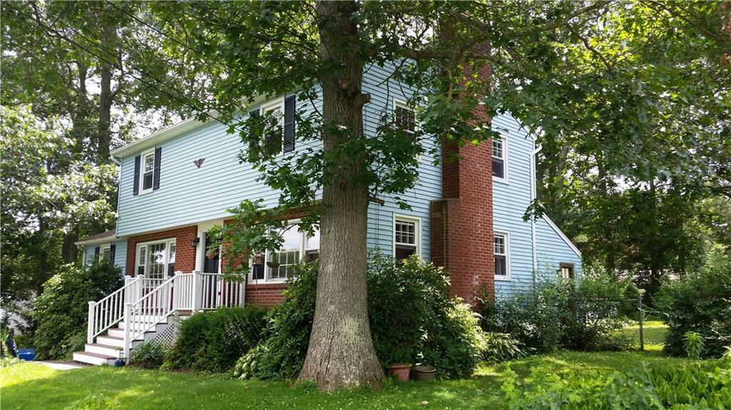 a front view of a house with a yard and trees