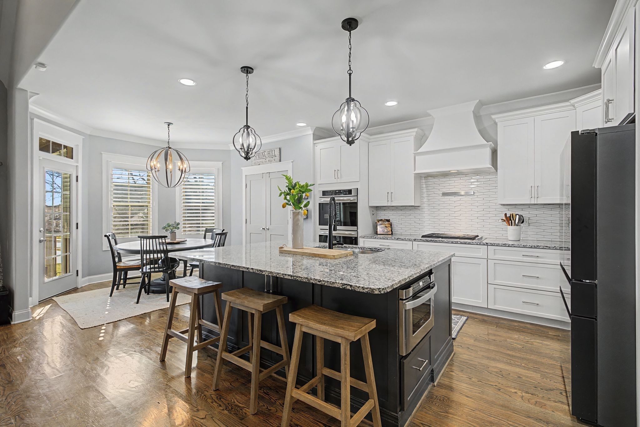 2965 Stewart Campbell Pointe Spring Hill, TN 37174 - Photo 13 of 48 a kitchen with stainless steel appliances kitchen island granite countertop a table chairs and a wooden floors